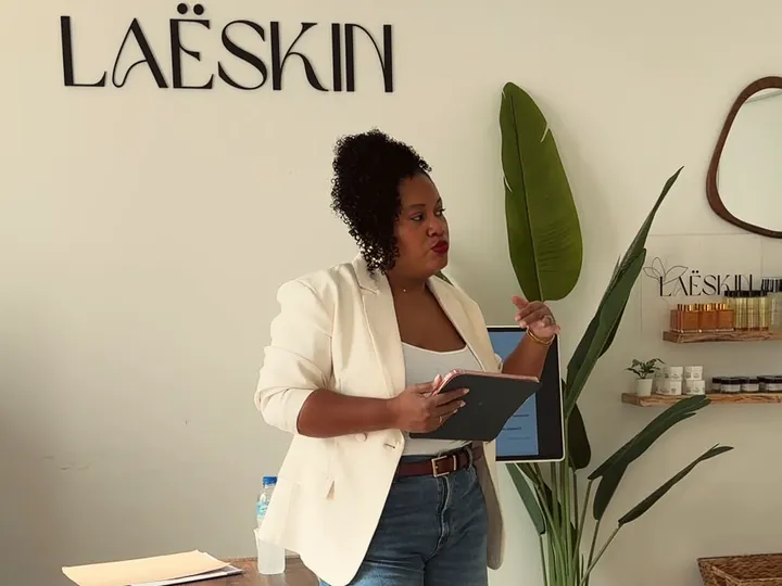 Laëtitia, tablette en main, devant l'enseigne LaëSkin